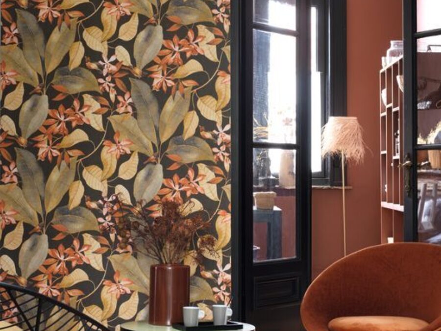 Behang met bladeren in woonkamer met houten vloer, moderne meubelen en zwarte kozijnen.