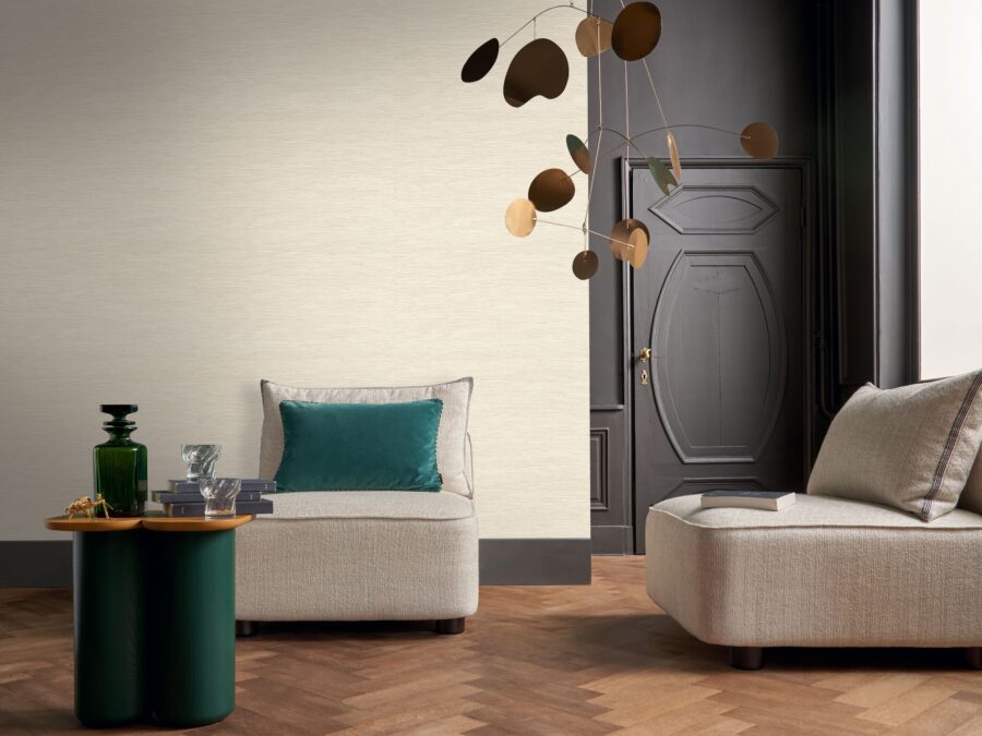 Elegante woonkamer met luxe linnen behang in beige, visgraat vloer en beige fauteuils.