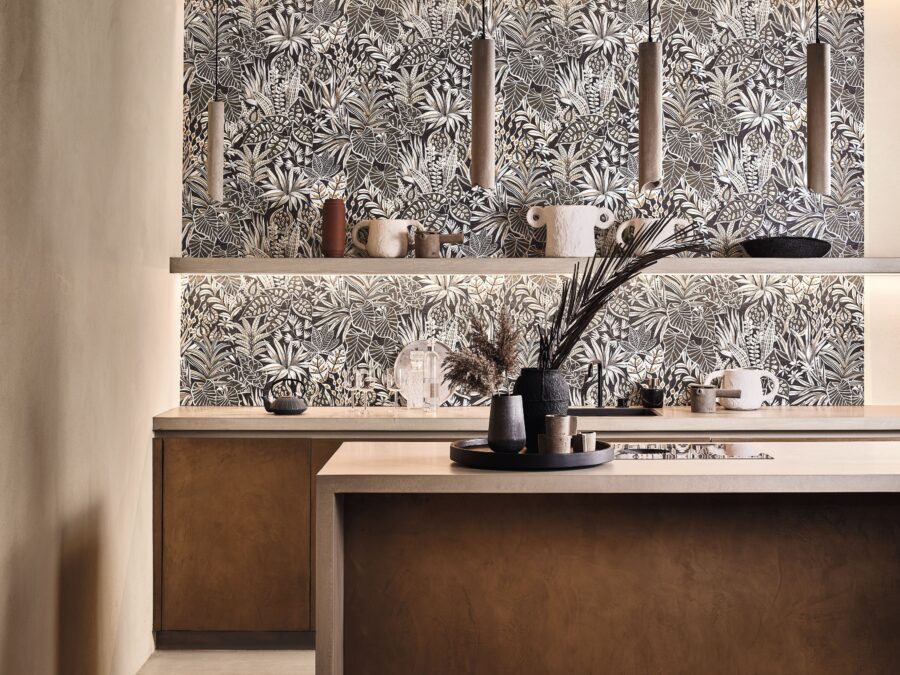 Keuken met houten kasten, stenen aanrechtblad en luxe behang met bladeren print in beige en grijstinten, merk Casamance.