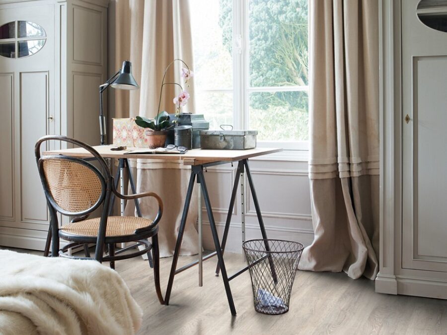 Slaapkamer in landelijke stijl met meubels in beige tinten, katoenen gordijnen en een robuuste houten laminaatvloer.