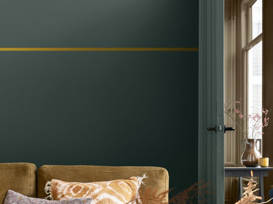 Flexa Kleurentrends 2025 Kleur van het Jaar 2025 True Joy detail horizontale smalle lijn in geel schilderen op donkere muurverf.