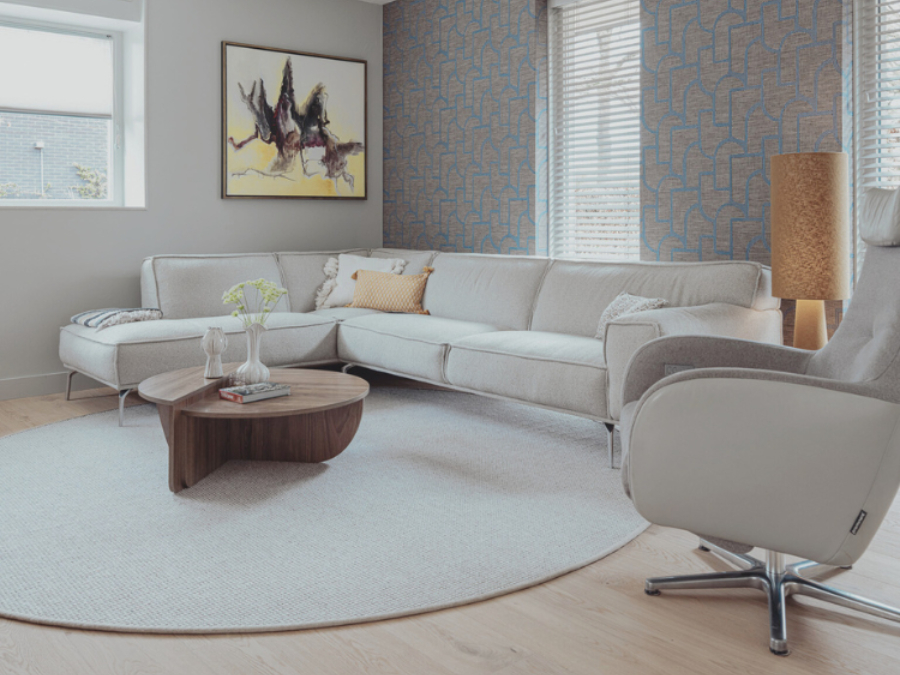 Zithoek na de make-over met warm Arte behang, rond vloerkleed, stijlvolle tv-kast en sfeervolle raambekleding