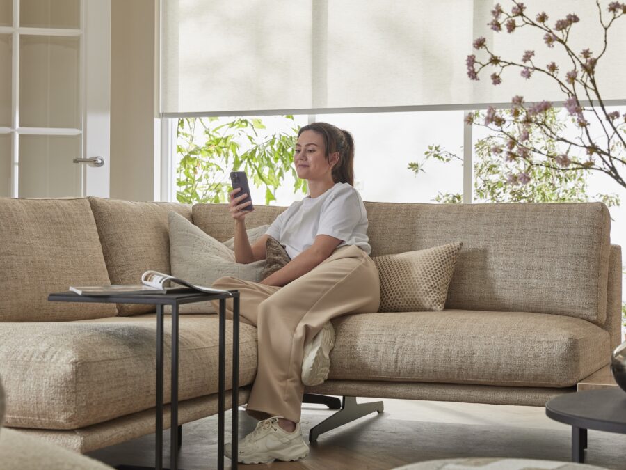 Vrouw bedient raamdecoratie met Apple Home-app op iPhone