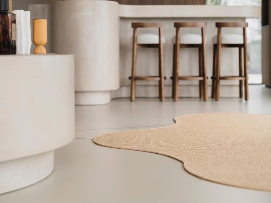 Beige organisch vloerkleed op betonlook grijze vloer