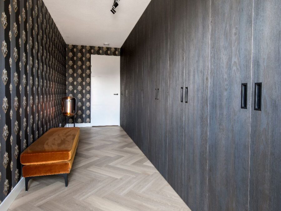 Donkerbruine draaideur kast op maat met zwarte greepjes, hotel chique stijl kamer.