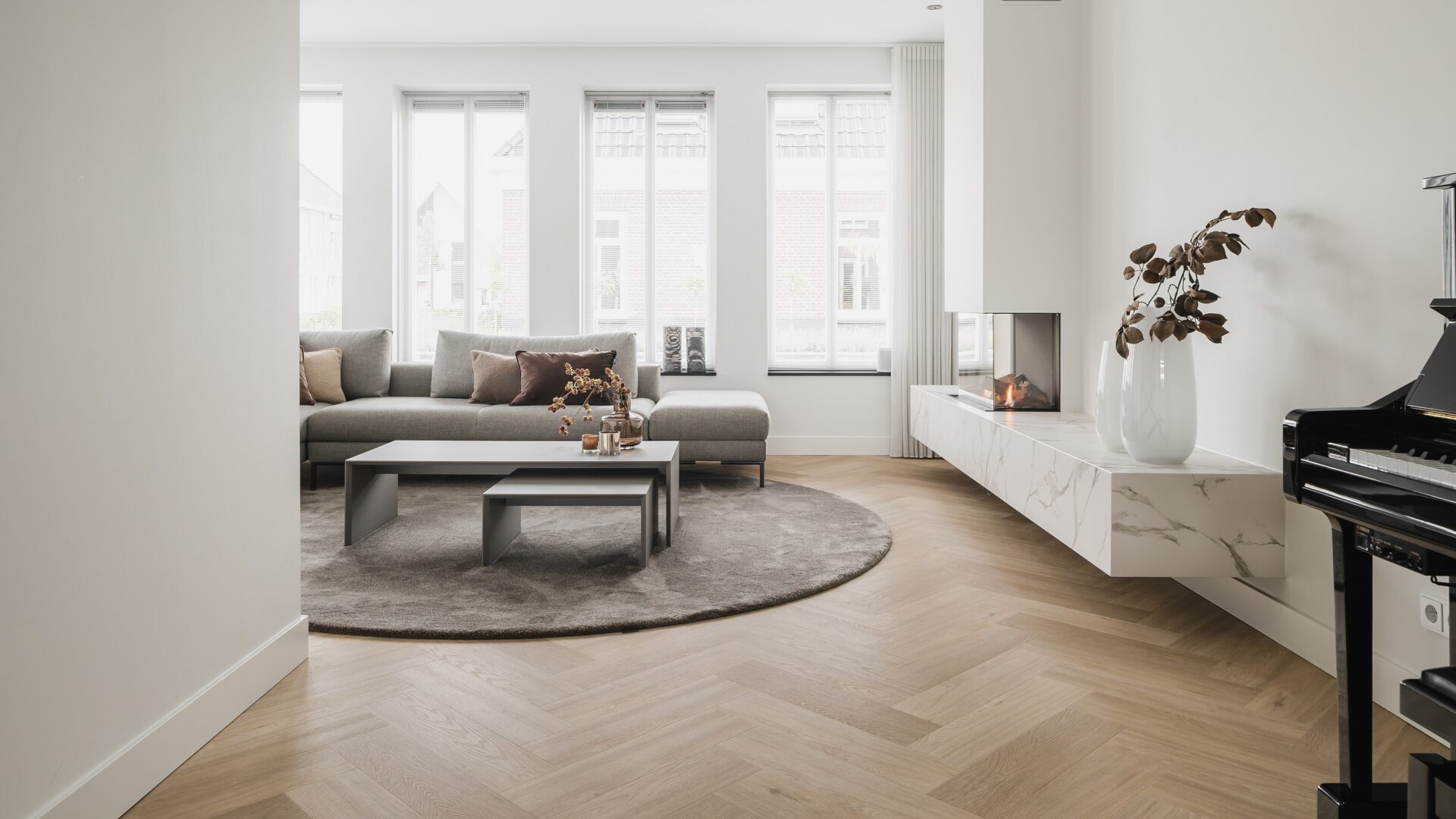 Visgraat vloer in woonkamer met gordijnen, kast en vloerkleed