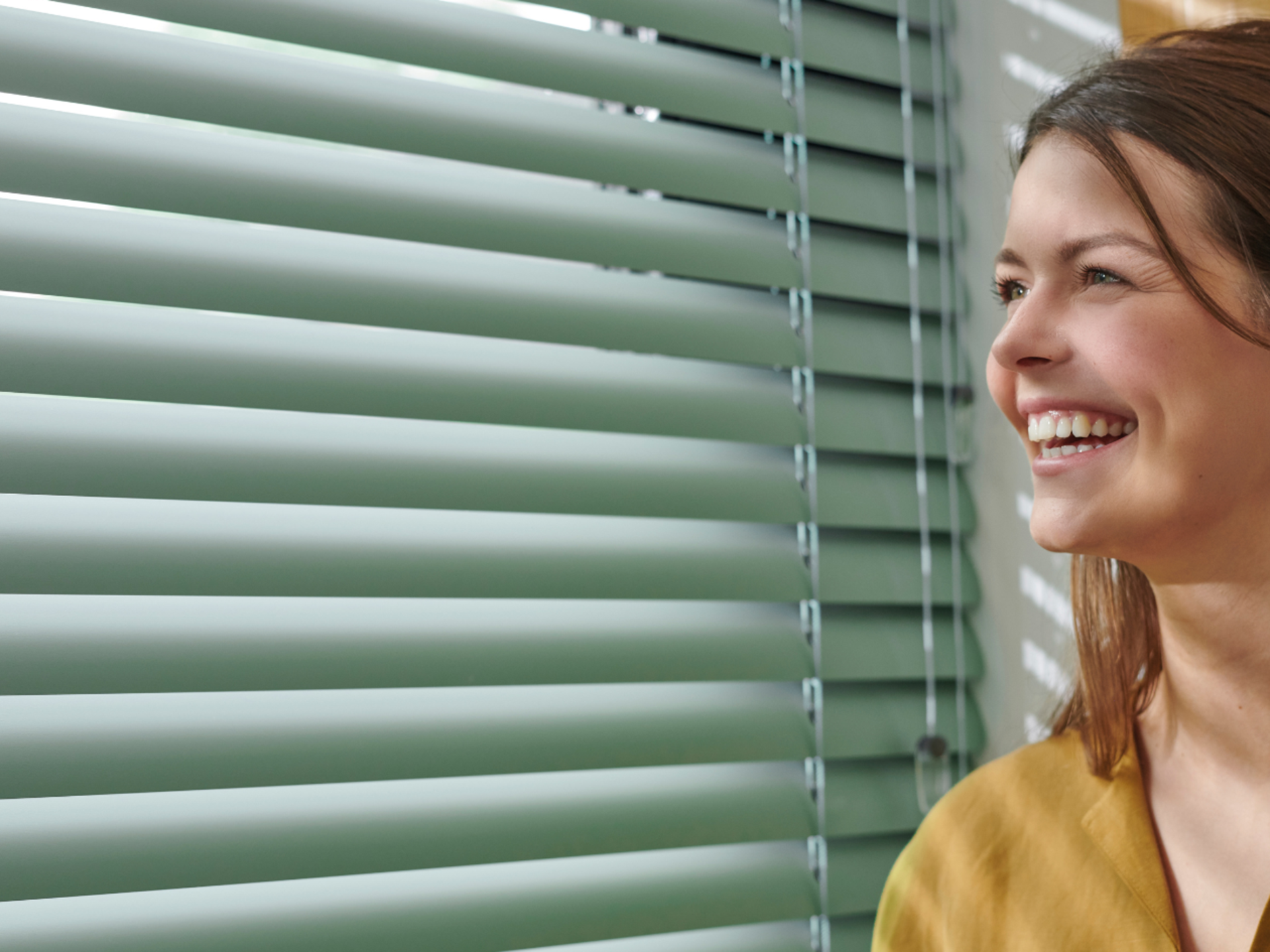 Groene horizontale jaloezieën met blije dame.