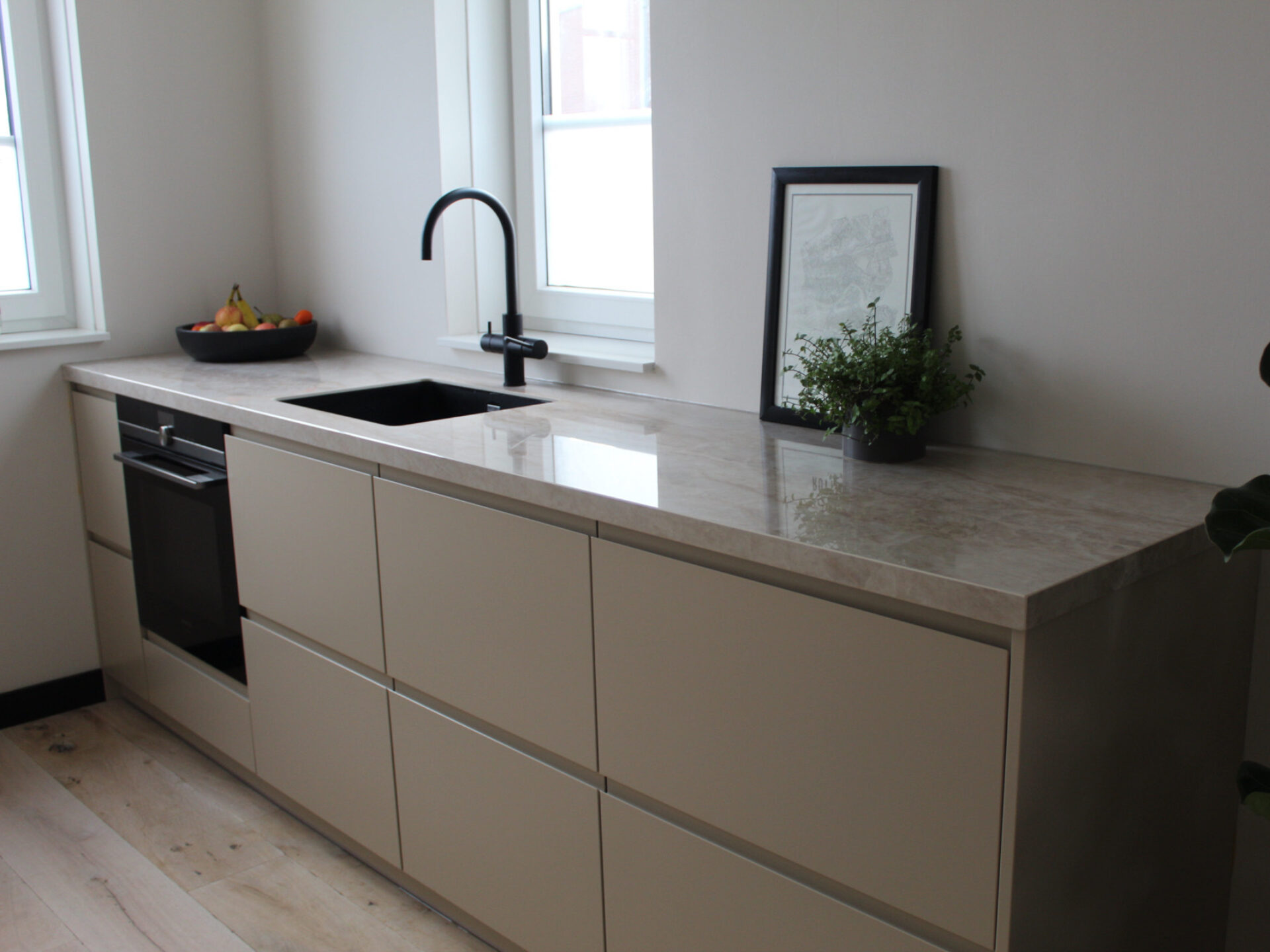 Moderne keuken met vernieuwde Hello Front fronten en werkblad in strakke afwerking.