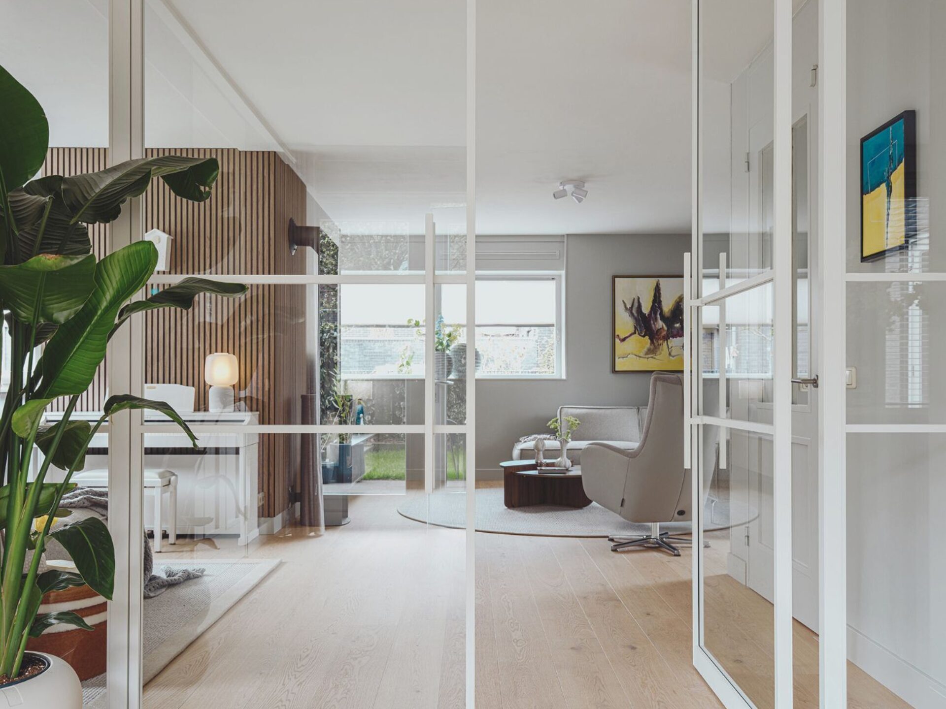 Witte metalen deuren in de woonkamer met een lichte eiken Lindura vloer