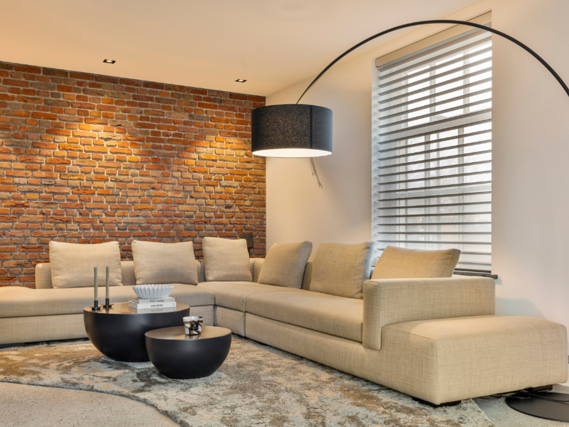 Moderne woonkamer met raamdecoratie en schoonmetselwerk