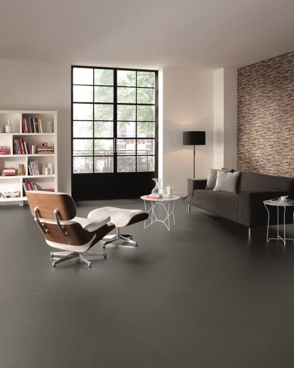 Industriele woonkamer met donkere betonlook vloer.