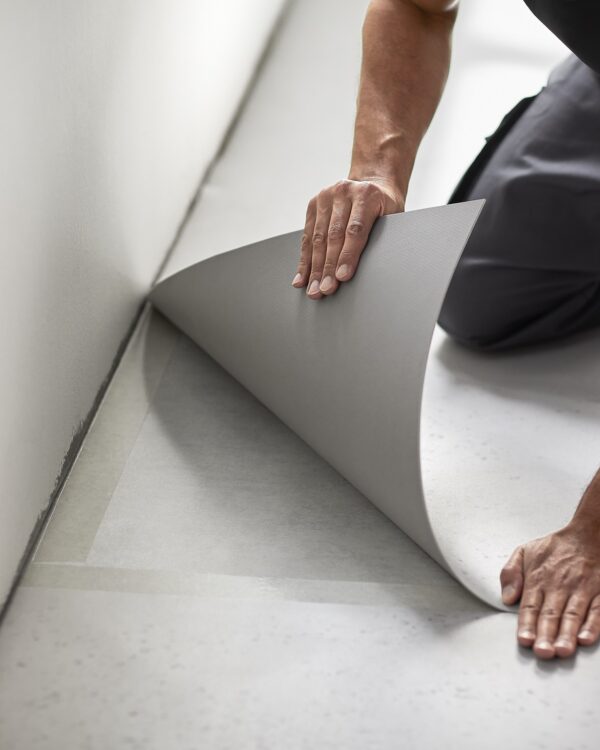 Leggen van een vinylvloer detail van stukje vinyl en stoffeerder.