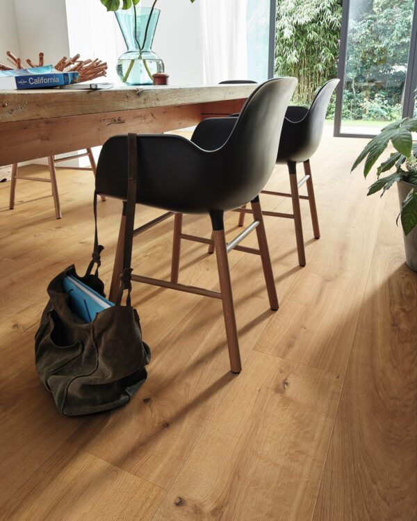 Eetkamer met houten meubelen, laminaatvloer in warme tint en veel kamerplanten voor een natuurlijke stijl interieur.