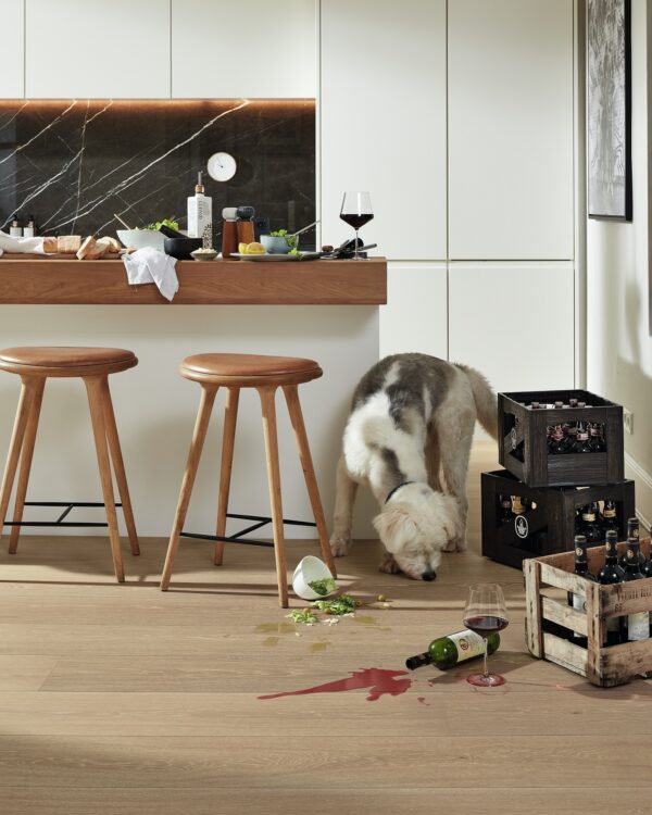 Keuken met eiken houtlook laminaat, witte kasten en marmerenwandbekleding.