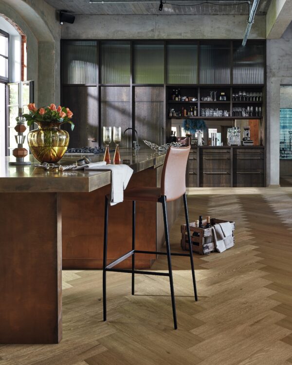 Ruime keuken met bar, visgraat laminaatvloer en kastenwand voor extra opbergruimte.