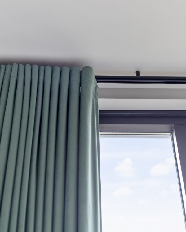 Close-yup van blauwe gordijnen en zwarte gordijn rail