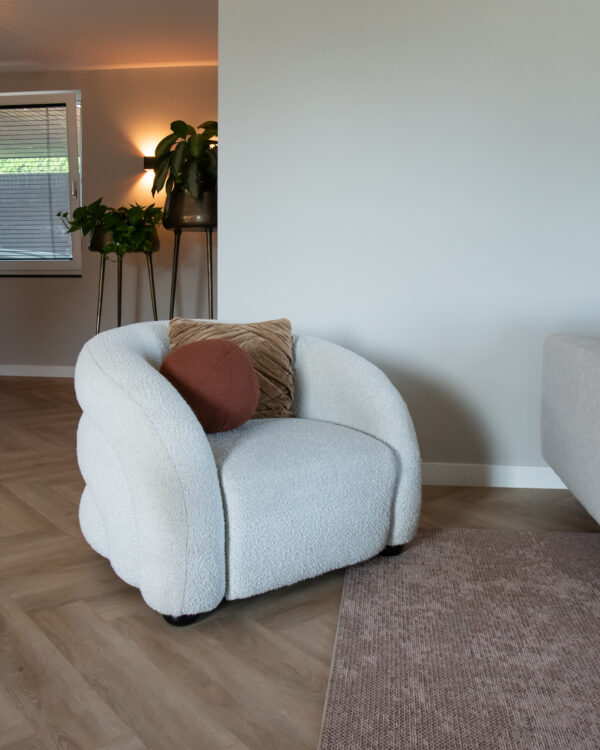 Fauteuil in de woonkamer met vloerkleed en visgraatvloer