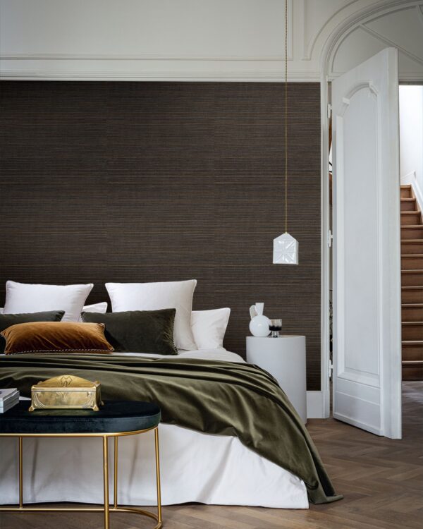 Luxe linnen behang in warme bruintint in slaapkamer met tweepersoonsbed en fluweel bedsprei.