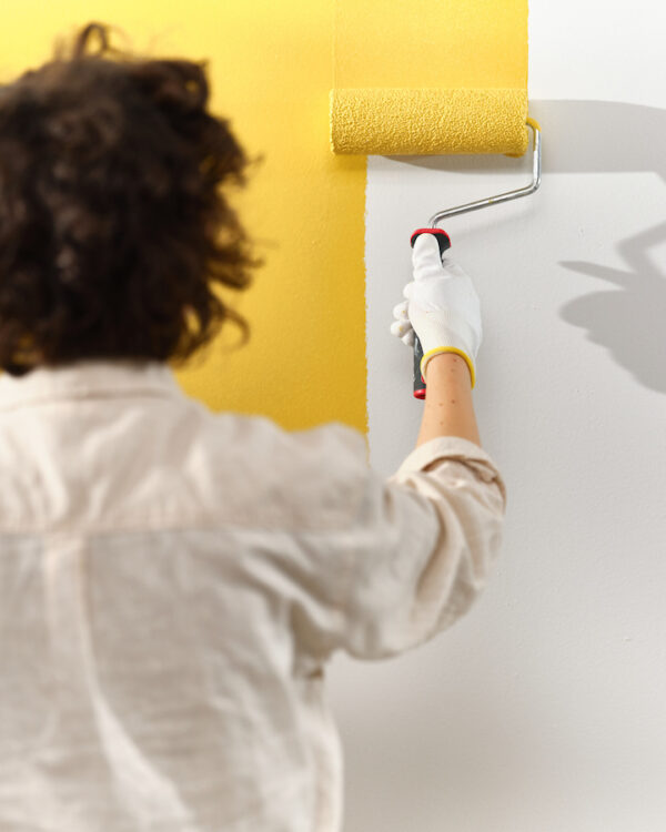 Vakman die muur schildert in de trendkleur True Joy van Flexa.