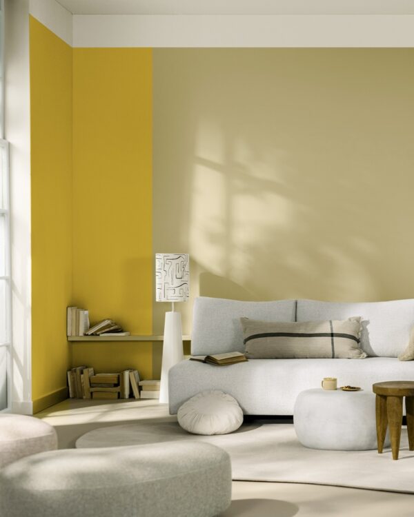 Woonkamer in beige en aardetinten met witte meubelen en een geel kleuraccent op de muur, Flexa True Joy kleur.