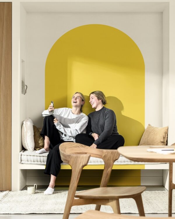 Eethoek in Scandinavische stijl met houten meubelen, lichtgrijze gietvloer en muurverf in wit en geel, True Joy Flexa kleur van het jaar 2025.