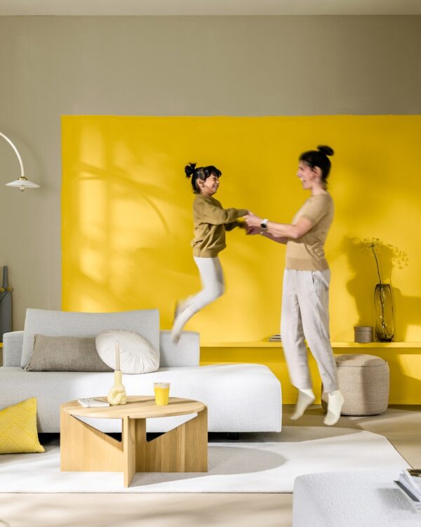 Woonkamer in wit en beige tinten met statement muur in Flexa True Joy en witte meubelen.