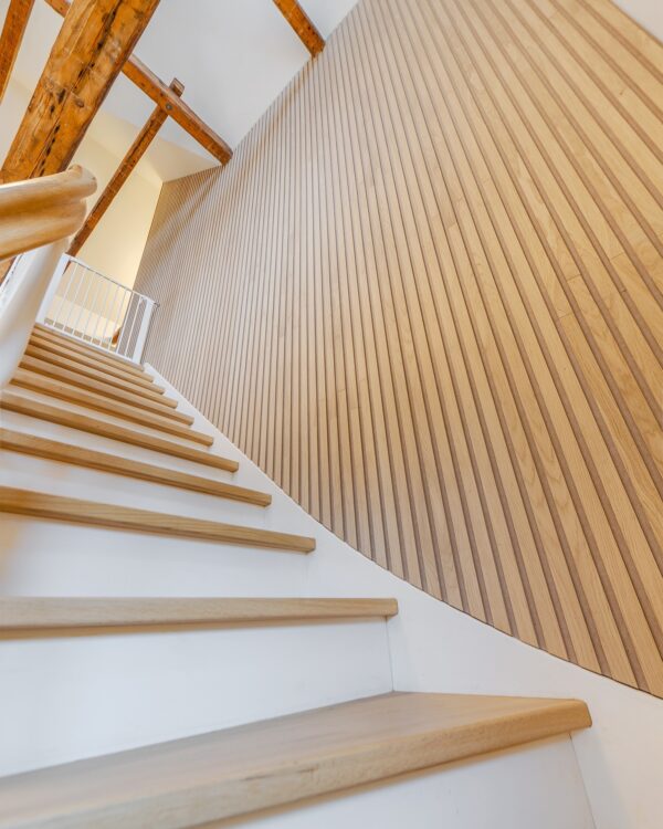 Houten wandpaneel aan de muur bij de trap