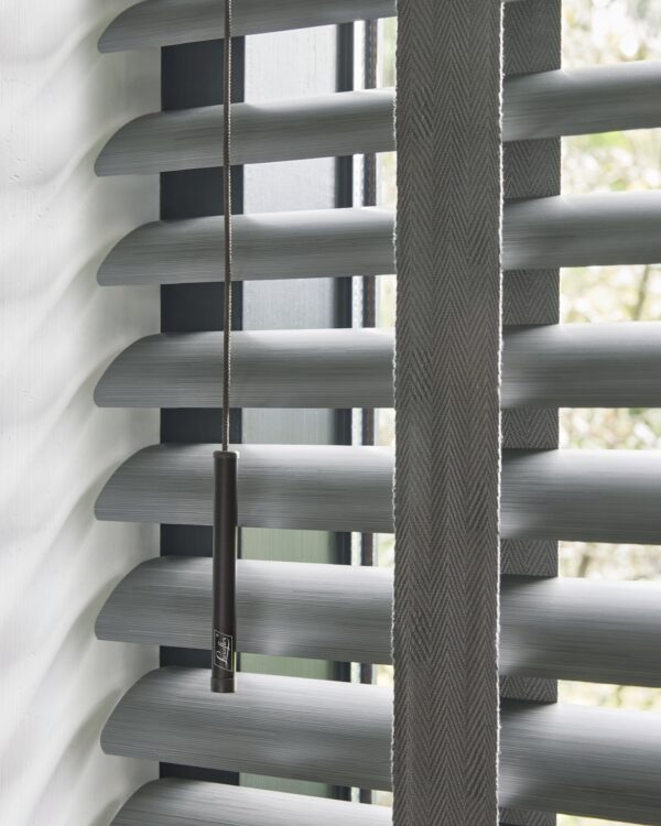 Detail aluminium jaloezie met brede lamellen en ladderband