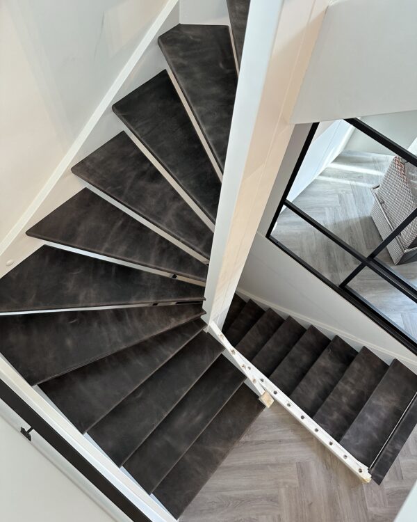 Grijze leren trap met grijze visgraatvloer