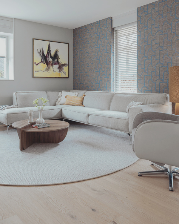 Zithoek na de make-over met warm Arte behang, rond vloerkleed, stijlvolle tv-kast en sfeervolle raambekleding