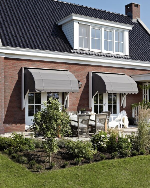 Grijze markiezen bij vrijstaand huis met witte kozijnen en tuin