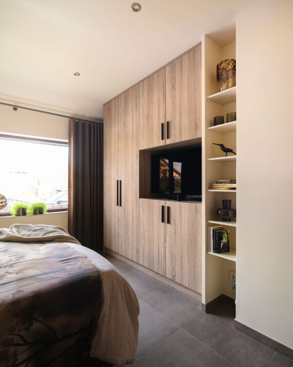 Houtlook kast op maat met zwarte grepen en tv-nis