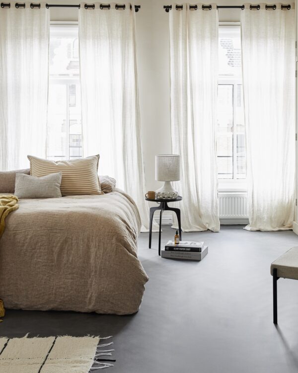 Slaapkamer met landelijke inrichting gecombineerd met moderne betonlook vloer.