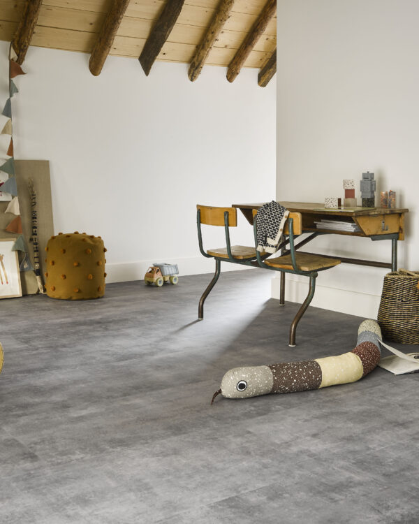 Lichtgrijze pvc-vloer in landelijke woonkamer met houten balken en grote ramen.