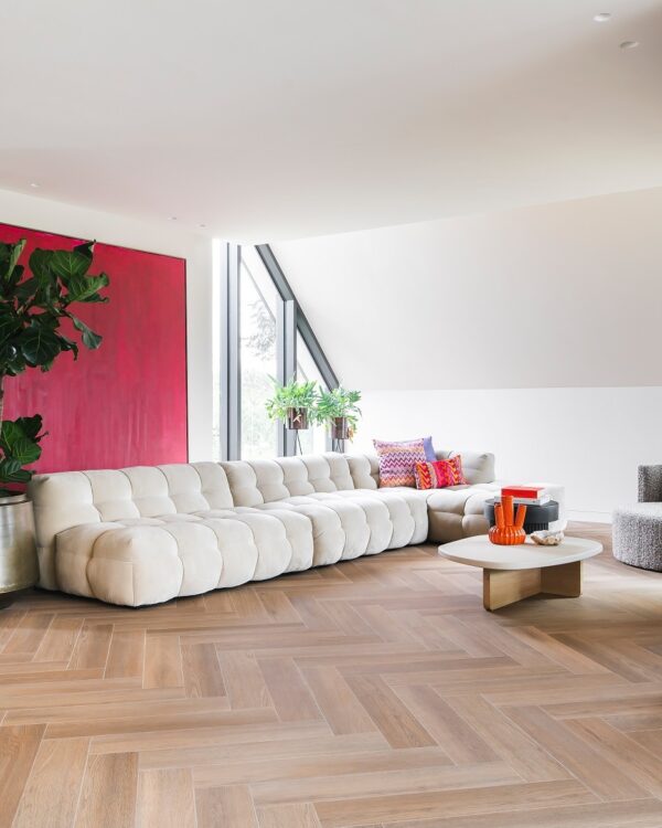 Woonkamer met gezellige visgraat pvc vloer en moderne wandbekleding.