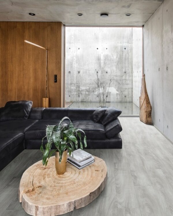 Moderne woonkamer met zwarte leren hoekbank, houten wandkast, glazen pui en bruin grijze pvc-vloer in robuuste stijl.