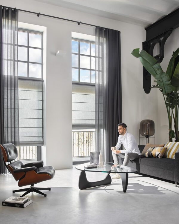 Vouwgordijn en vitrages in industrieel loft met man