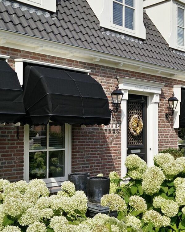 Zwarte markiezen bij eigentijdse woning met tuin