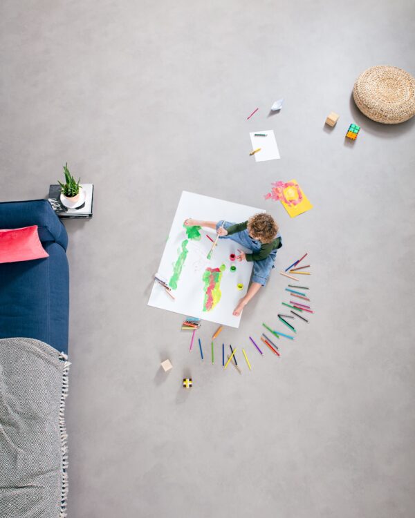 Kinderkamer met Novilon betonlook vloer die tegen een stootje kan.