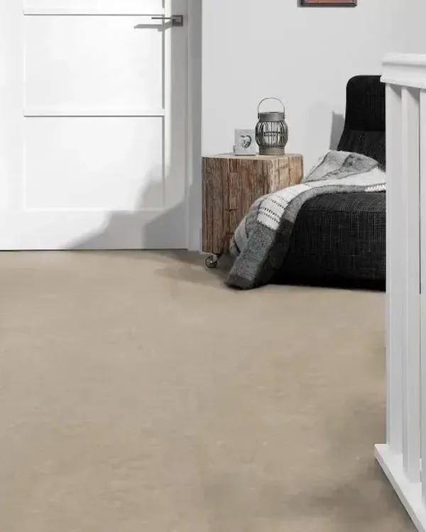 Overloop met beige marmoleumvloer, zwarte stoel met plaid, houten bijzettafel en witte trapleuning