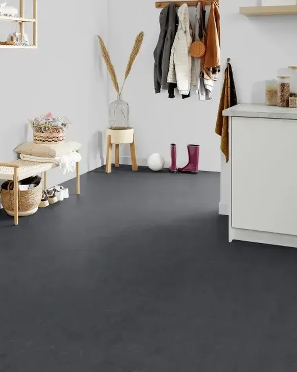 Hal en bijkeuken met donkergrijze marmoleumvloer, houten bankje, kapstok en witte kastjes
