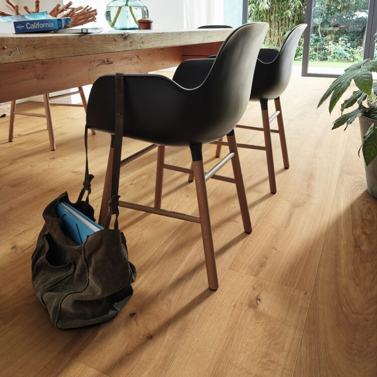 Eetkamer met houten meubelen, laminaatvloer in warme tint en veel kamerplanten voor een natuurlijke stijl interieur.