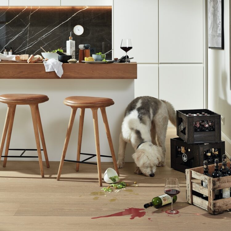 Keuken met eiken houtlook laminaat, witte kasten en marmerenwandbekleding.