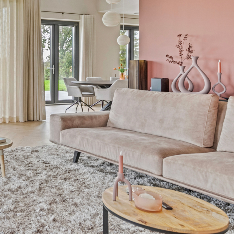Sfeerbeeld van woonkamer met vloerdkleed, oudroze muurverf en inbetweens