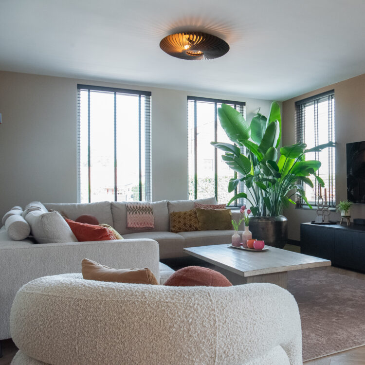 Sfeerfoto van een woonkamer met houten jaloezieën en een kachel