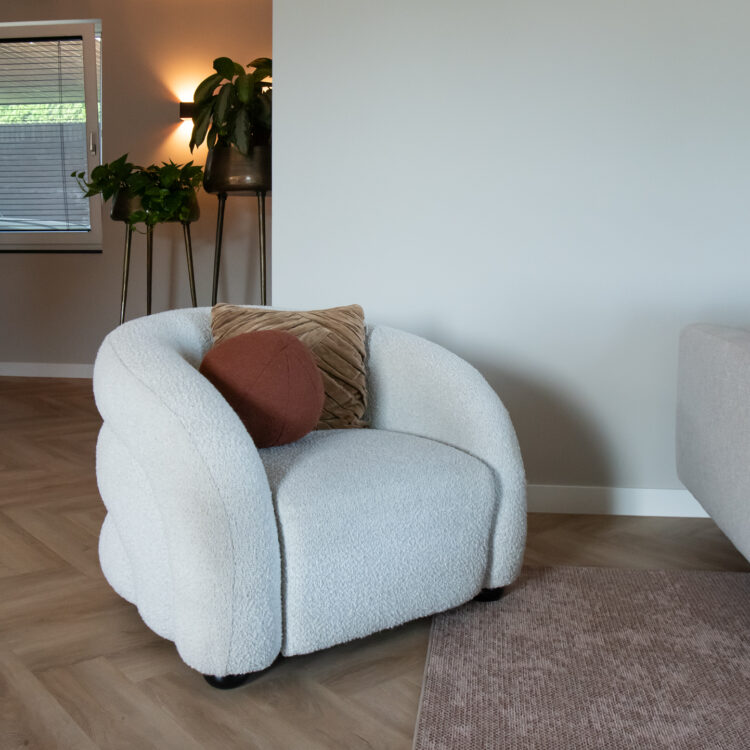 Fauteuil in de woonkamer met vloerkleed en visgraatvloer