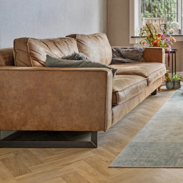 Visgraat vloer met grijze vloerkleed in de woonkamer