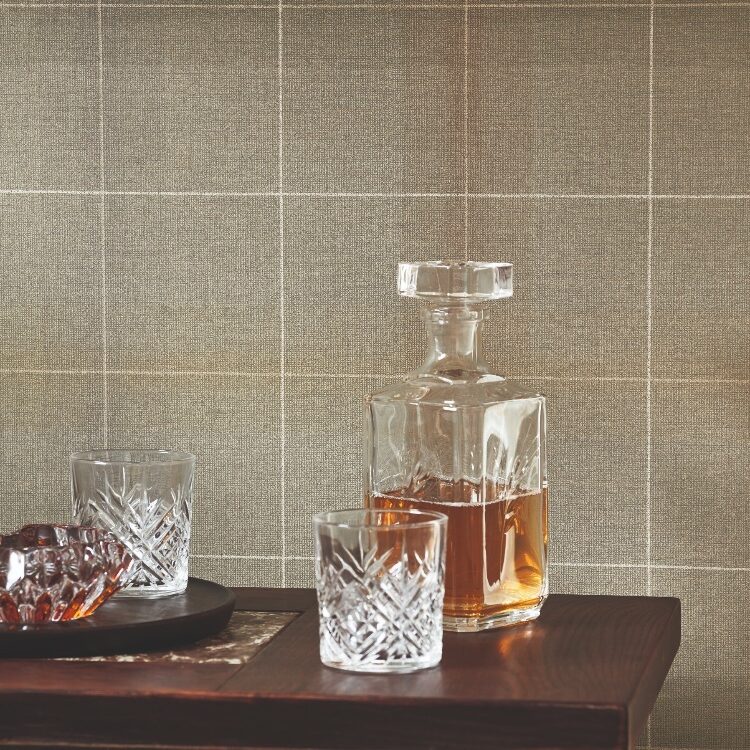 Casadeco Archie Kaki behang op de muur achter een tafel