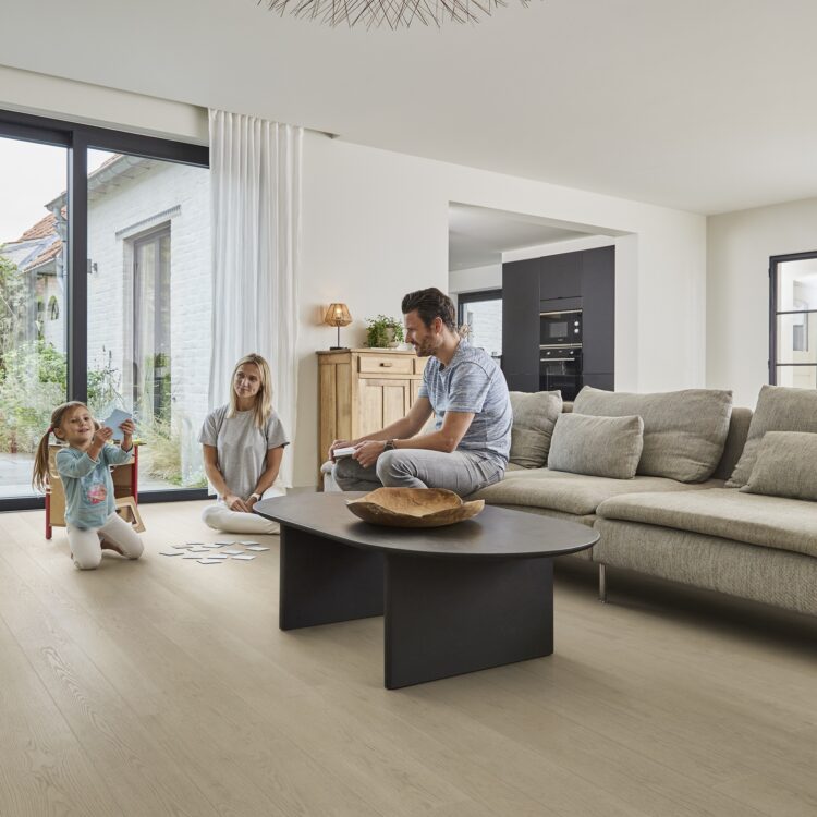 Woonkamer met houtlook pvc-vloer, royale loungebank en modern interieur.