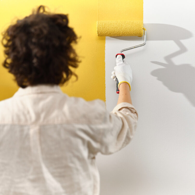 Vakman die muur schildert in de trendkleur True Joy van Flexa.